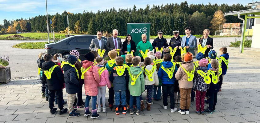 Schüler tragen alle die von den Ehrengästen überreichten Leuchtwesten