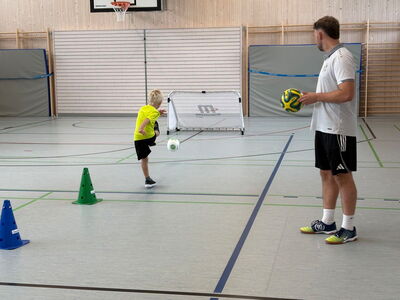 Ein Schüler schießt einen Ball auf ein Tor