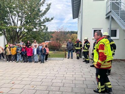 Schüler hören gespannt den Feuerwehrmännern zu