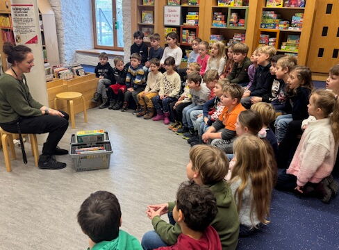 Kinder der Klassen 1a und 1b sitzen in der Straubinger Bücherei