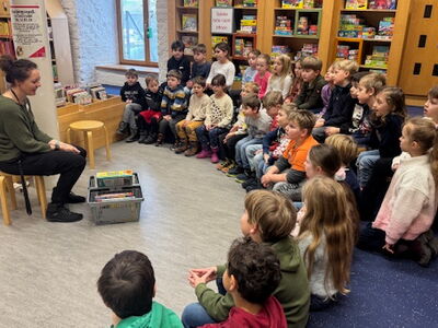 Kinder der Klassen 1a und 1b sitzen in der Straubinger Bücherei