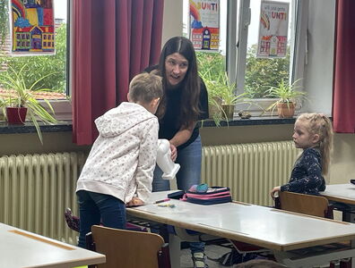 Frau Riedl mit einem Zahnmodell bei einem Schüler