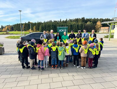 Schüler tragen alle die von den Ehrengästen überreichten Leuchtwesten