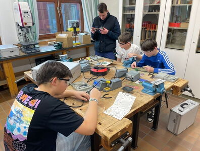 Schüler tüfteln gemeinsam auf einer Werkbank