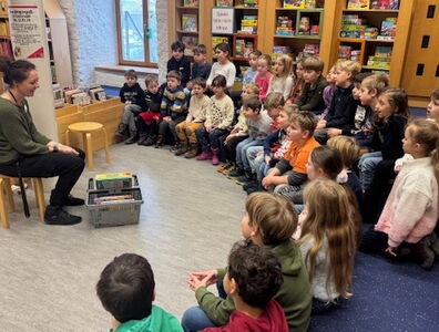 Kinder der Klassen 1a und 1b sitzen in der Straubinger Bücherei