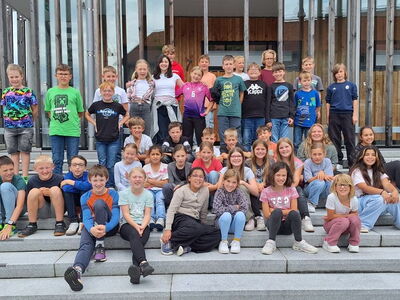 Die Klasse 4a und 4b zusammen im Gruppenbild auf einer großen Steintreppe vor der Volksakademie Freyung