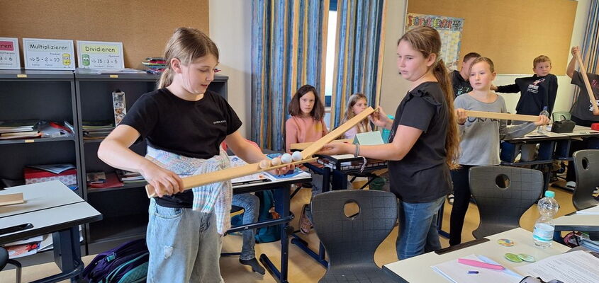 Schülerinnen spielen ein Spiel mit Kugeln