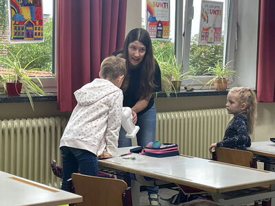 Frau Riedl mit einem Zahnmodell bei einem Schüler