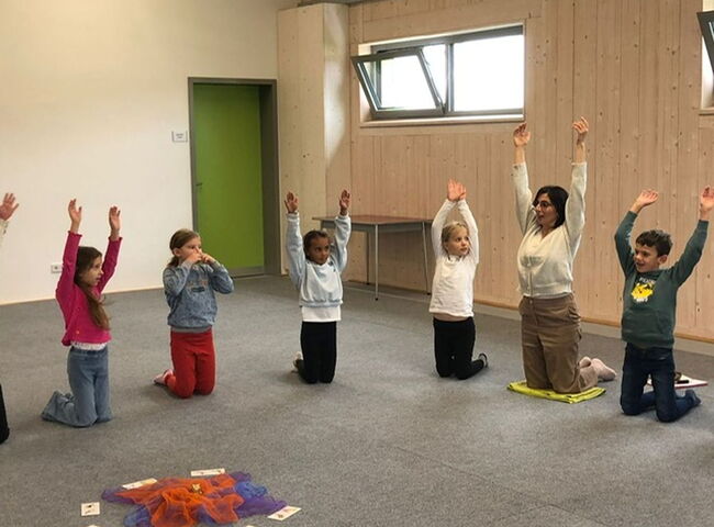 Kinder mit Frau Turhan bei einer Yogaübung