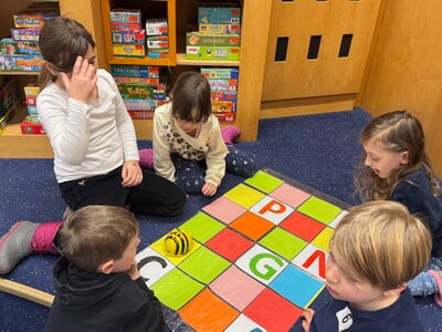 Schüler sitzen am Boden und spielen ein Spiel